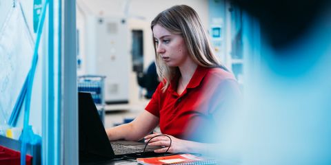 Häring-Auzubildende sitzt vor PC in Produktion