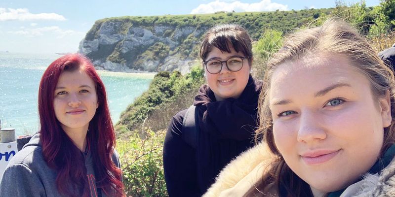 drei junge Mitarbeiterinnen Selfie Hintergrund Klippen und Meer 