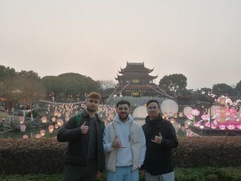 Drei Männder vor einem chinesischen Turm mit Laternen