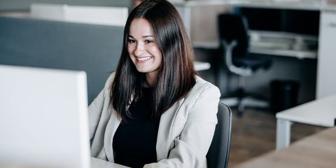 Häring-Auszubildende sitzt lachend vor PC